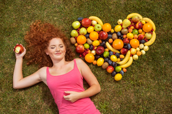 Girl with fruit laid out in the shape of a heart