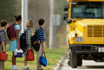 School children standing in line outside the school bus