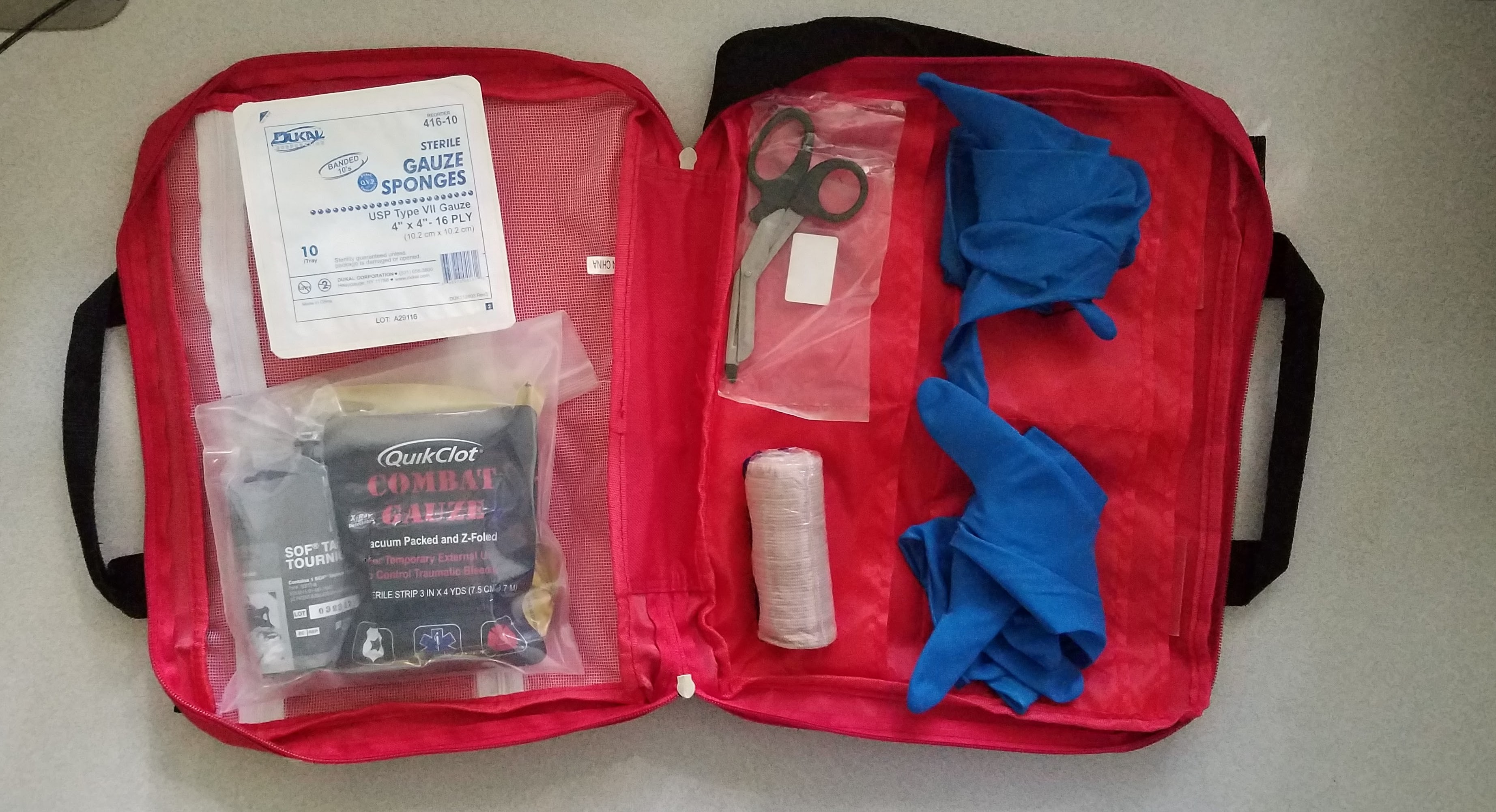 Stop the bleed kit opened showing gauze, sponges, scissors, and gloves