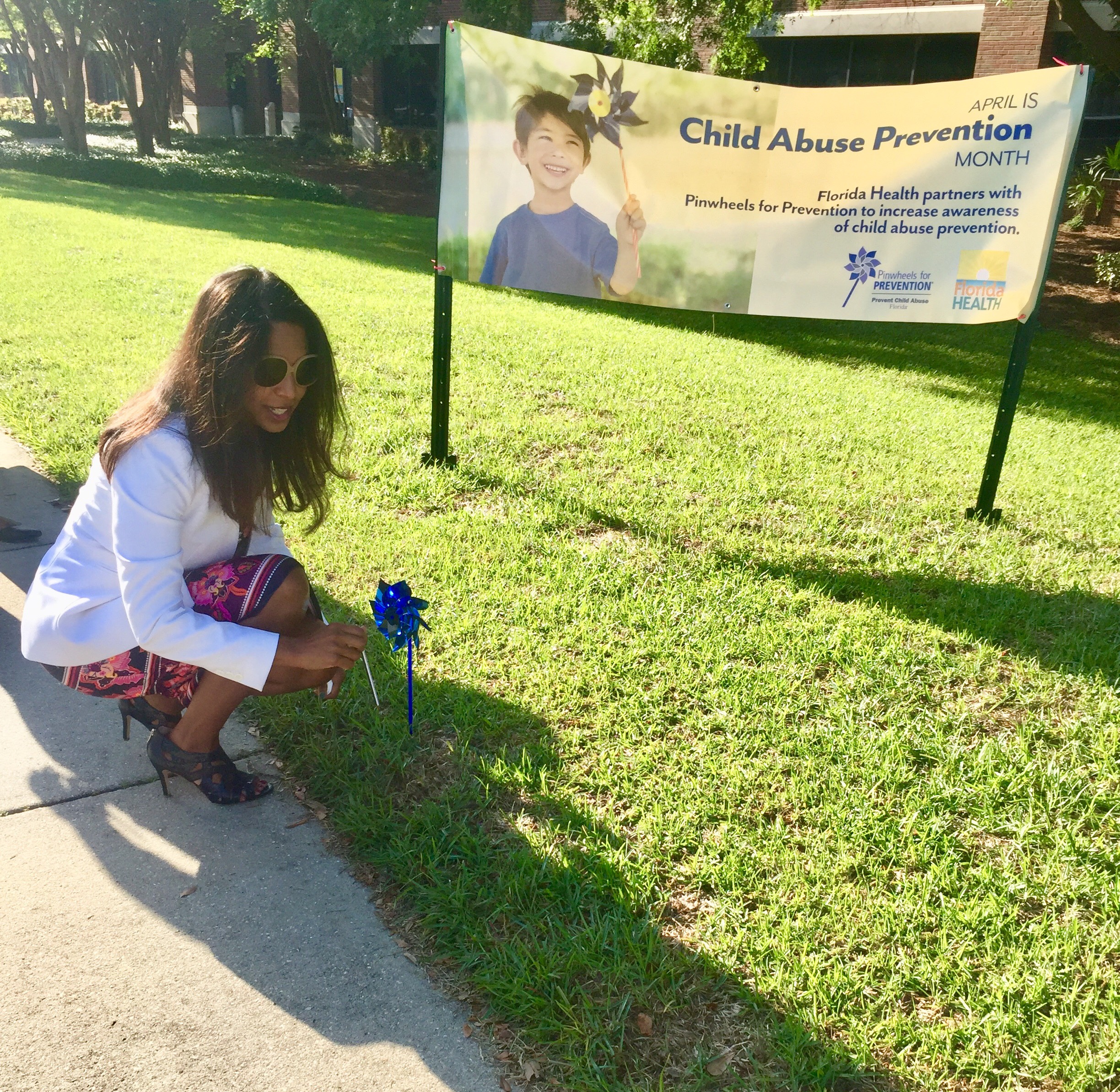 State Surgeon General and Secretary Dr. Celeste Philip plants a pinwheel at the department’s Pinwheels for Prevention recognition event.