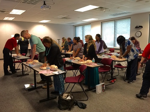 Employees performing hands only CPR training 