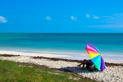 Florida Beach with an individual under a colorful beach umbrella
