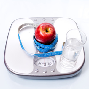 An apple and glass of water on a scale
