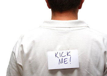 Kick me sign on the back of a man's shirt