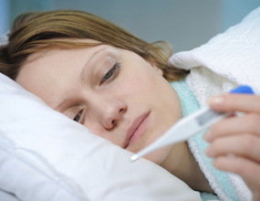 Sick woman holding a thermometer