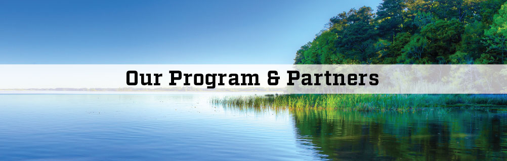 image of water and a tree covered shoreline with the words Our Program and Partners
