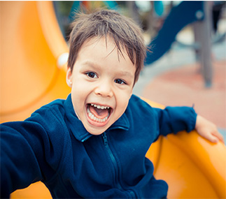 Photo of a boy on a slide, smiling