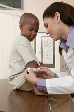 young boy gets a band-aid on arm