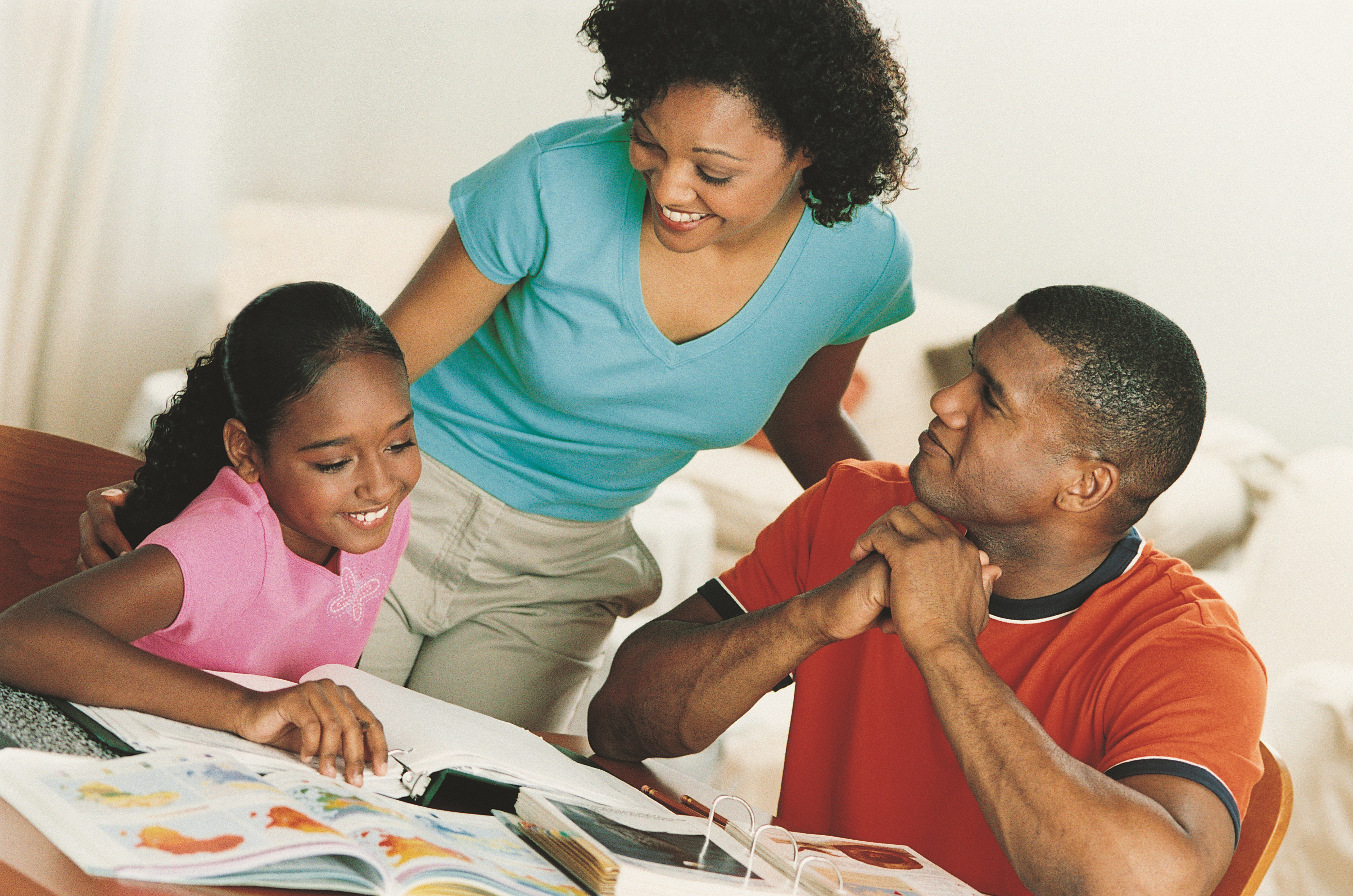 Mother and father helping their daughter with homework