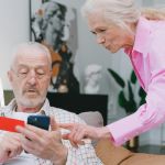 Man and woman looking for a special needs shelter on their phone.