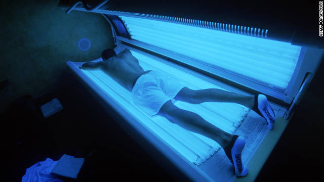 man lying face down in tanning bed