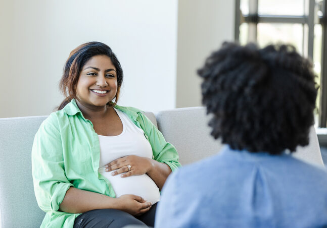 Pregnant woman talking to community member