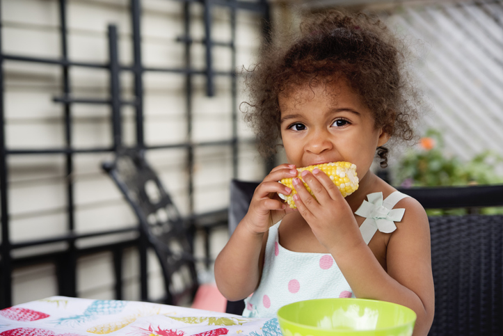 Toddler eating corn on the cob