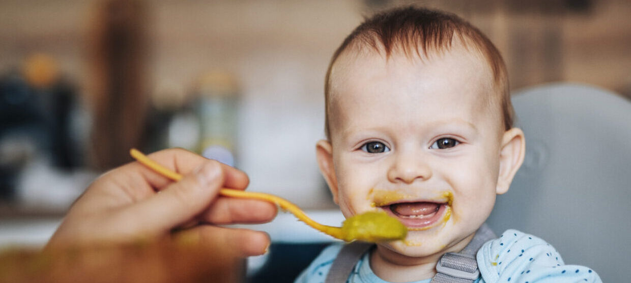 Infant eating in highchair