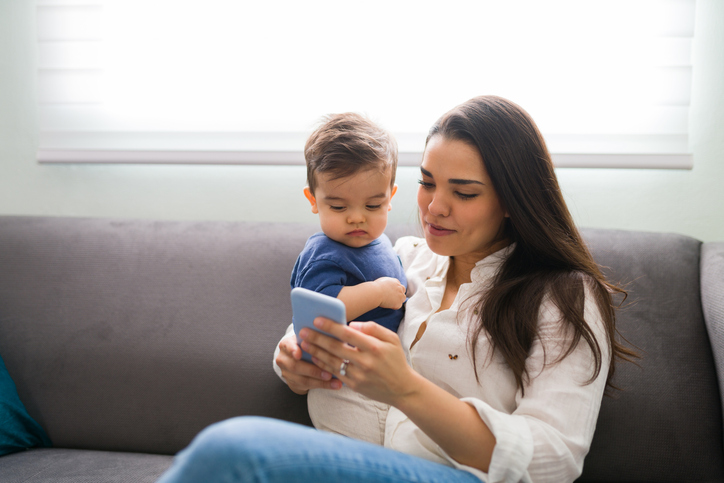 Young mother with son using smartphone