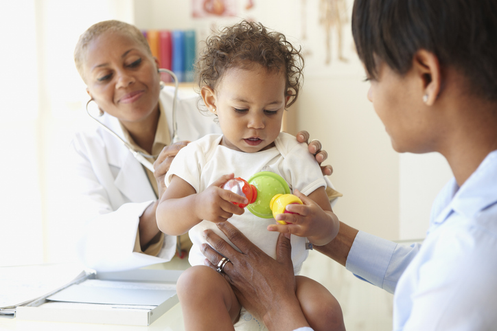 Mother with her infant child talking to doctor