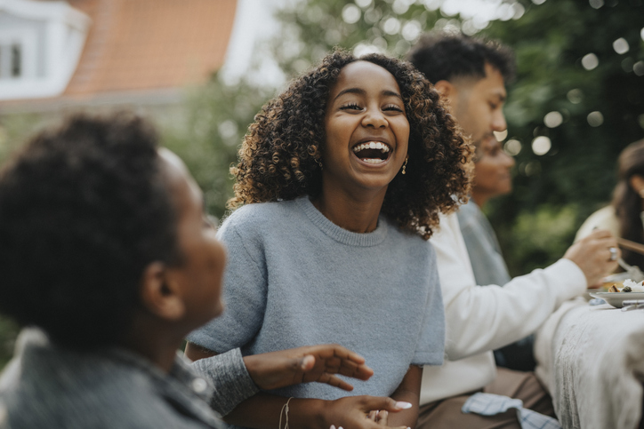 Happy adolescent girl laughing with friends