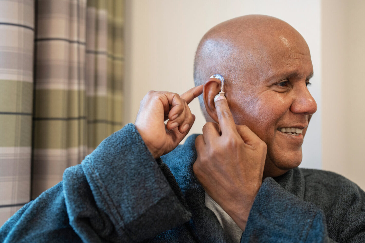 Older adult make inserting a hearing aid