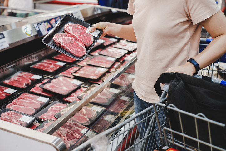 Refrigerated supermarket display case filled with various packaged meats