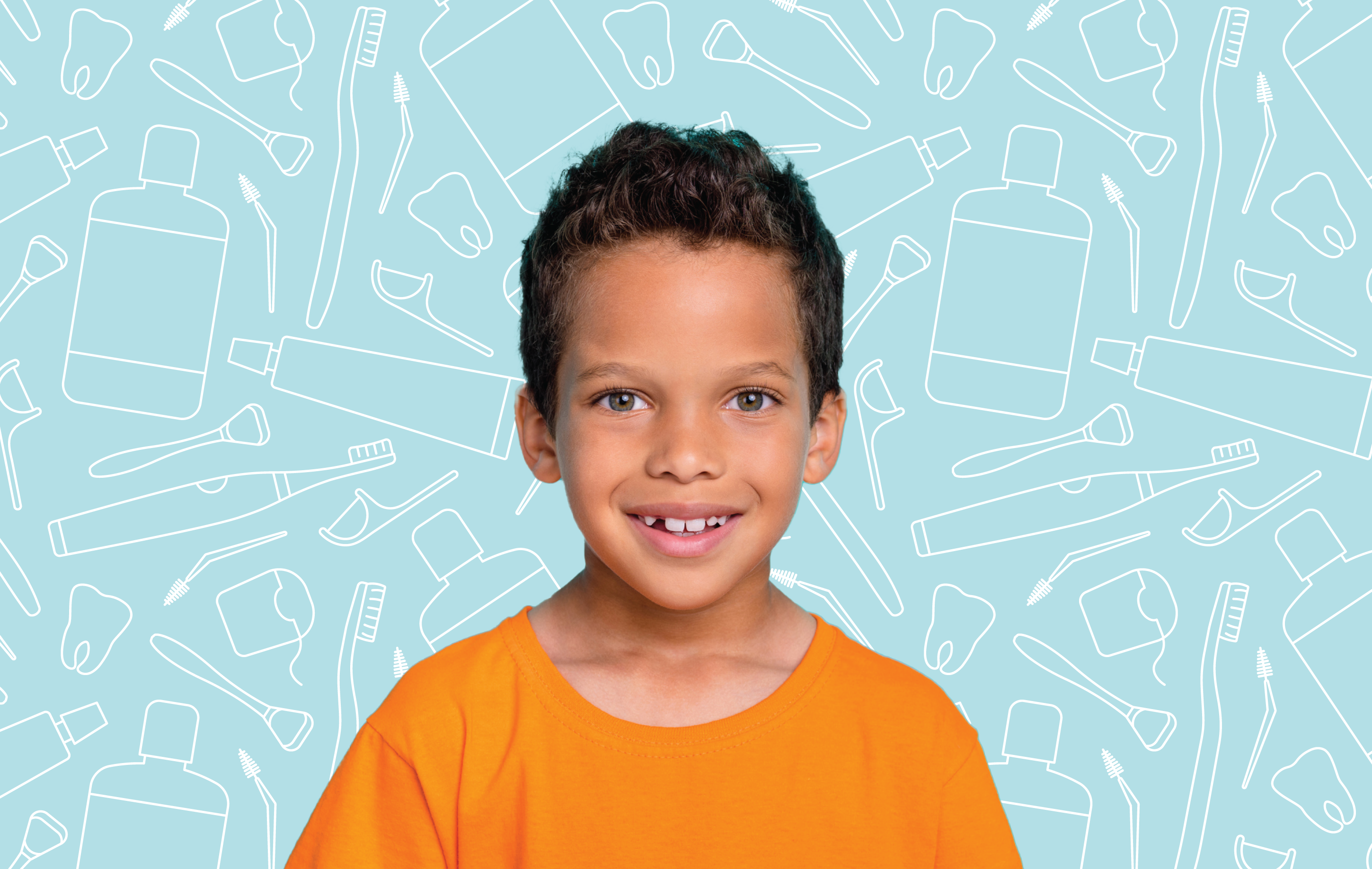 A smiling young boy sitting in front of dental hygiene products