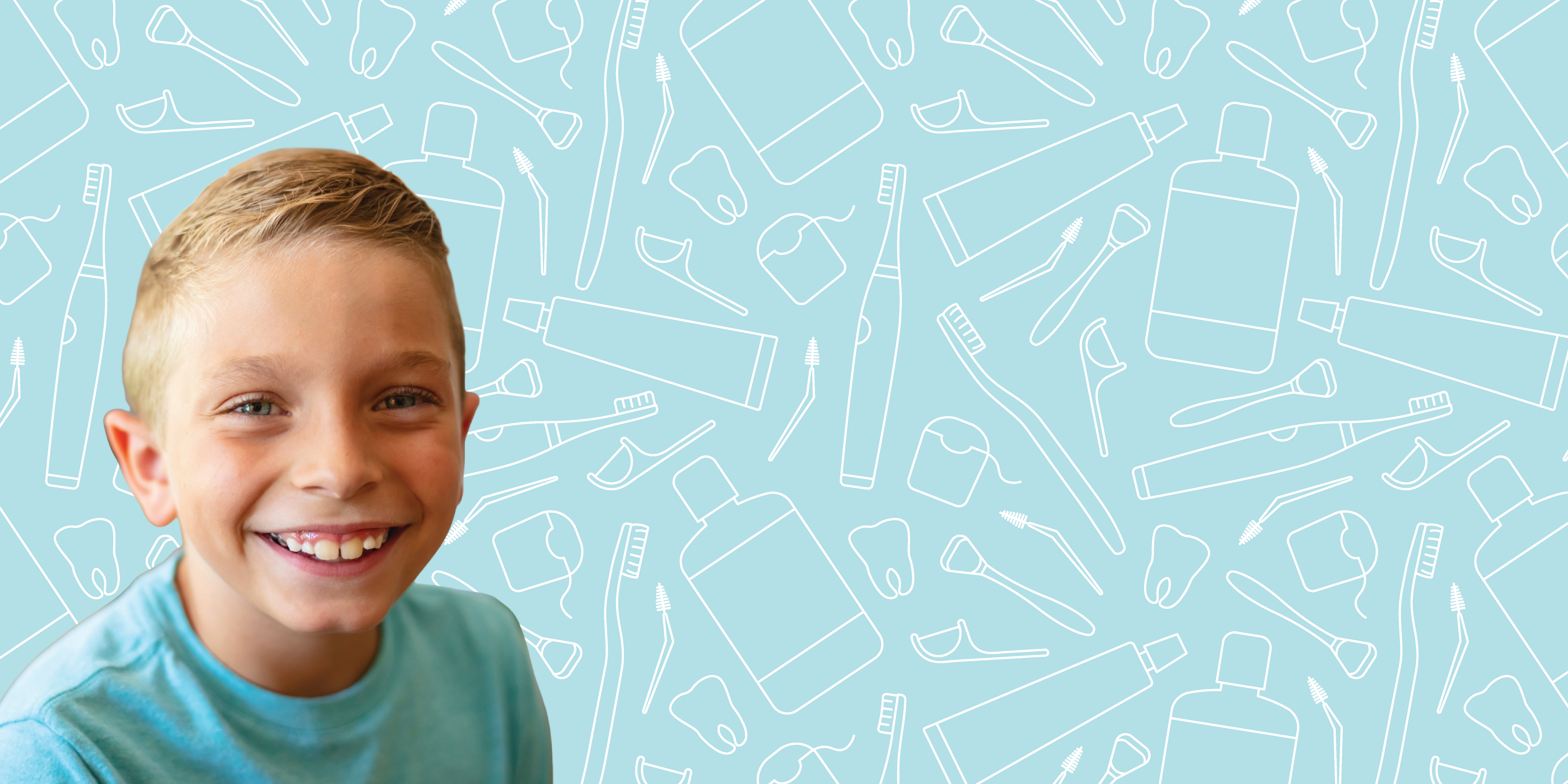 A smiling young boy sitting in front of dental hygiene products
