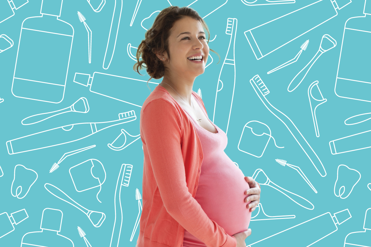 A smiling pregnant woman standing in front of dental hygiene products