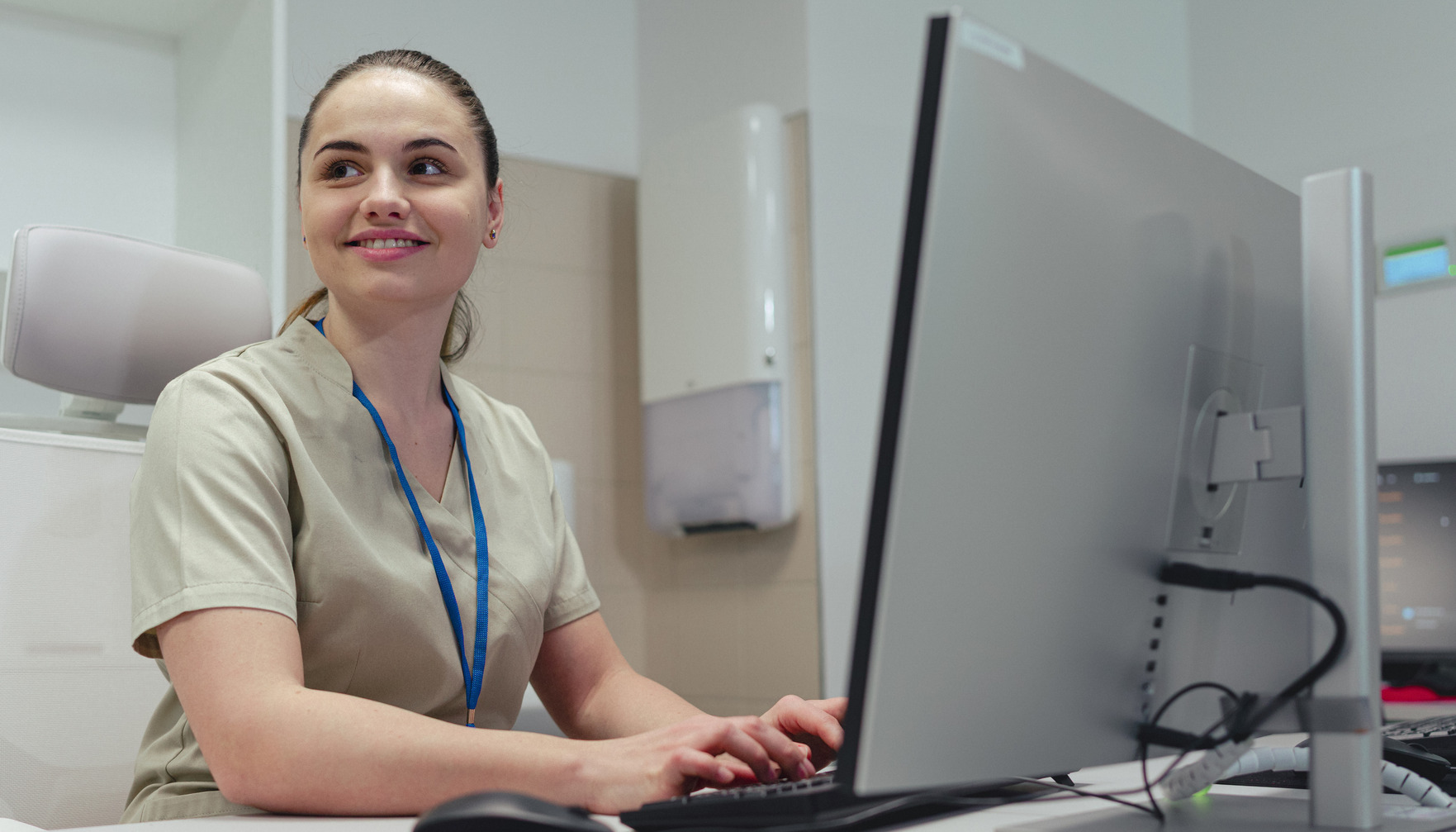 A smiling woman typing on a keyboard 