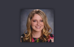 Headshot of a smiling young woman with long blonde hair.