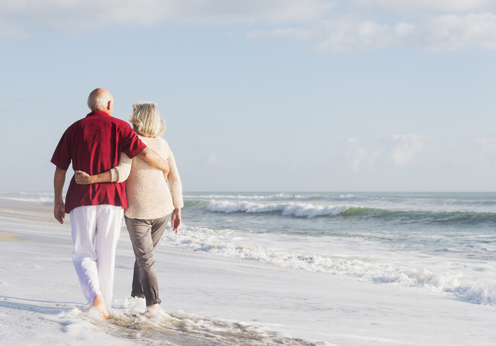 Senior couple walking on a sandy beach
